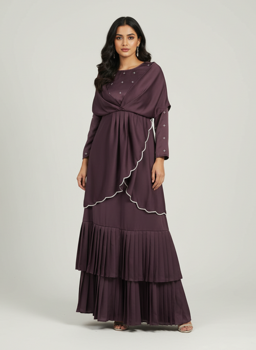 Woman wearing a long, dark purple dress with a white trim on a light gray background