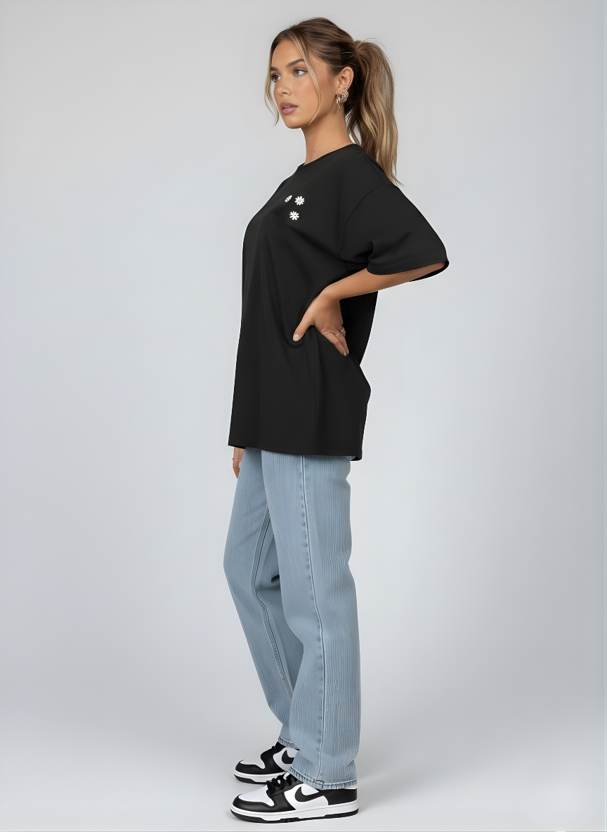 Person wearing a black oversized t-shirt and light blue jeans on a white background