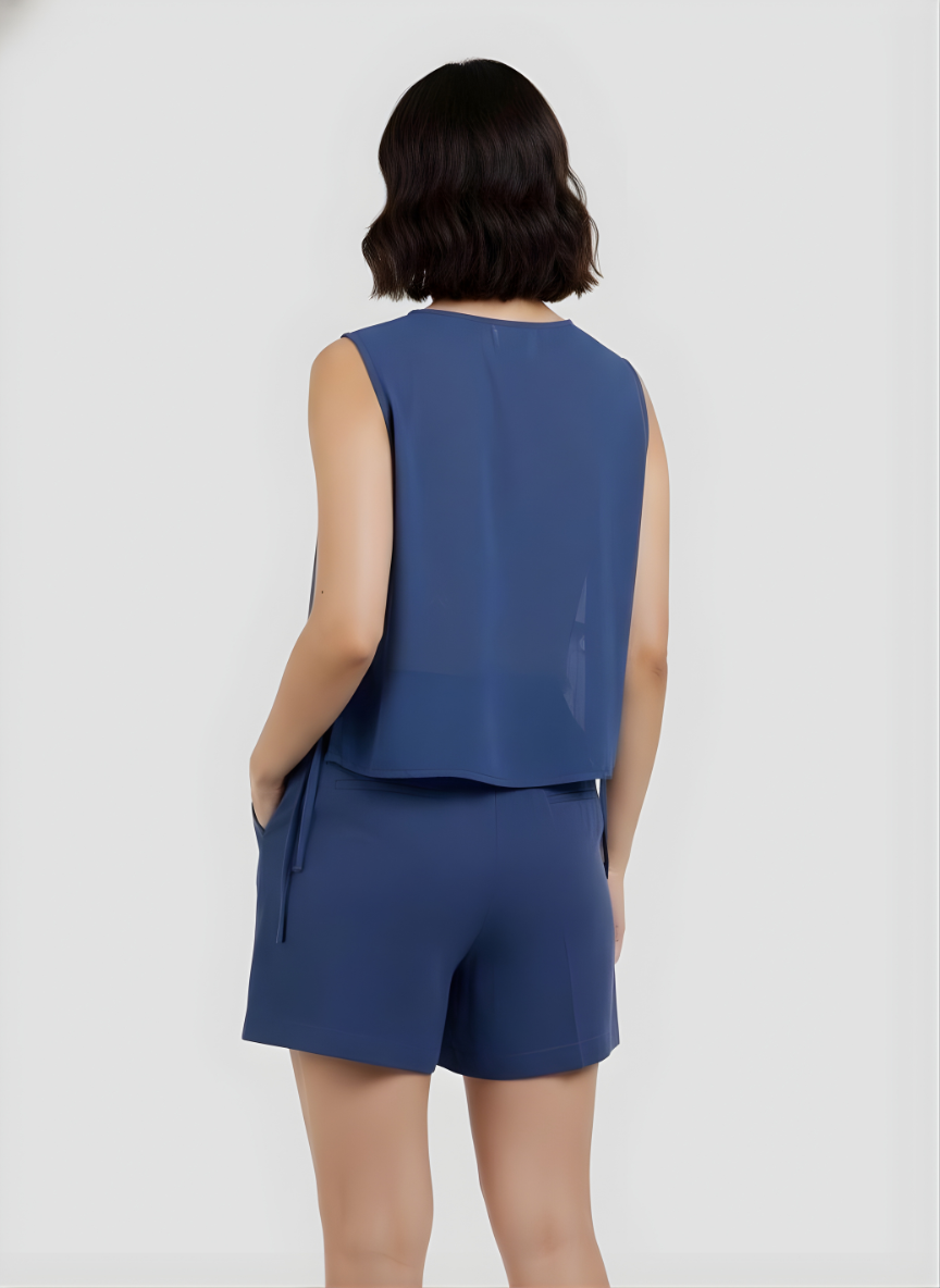 Woman wearing a blue sleeveless top and shorts set on a white background