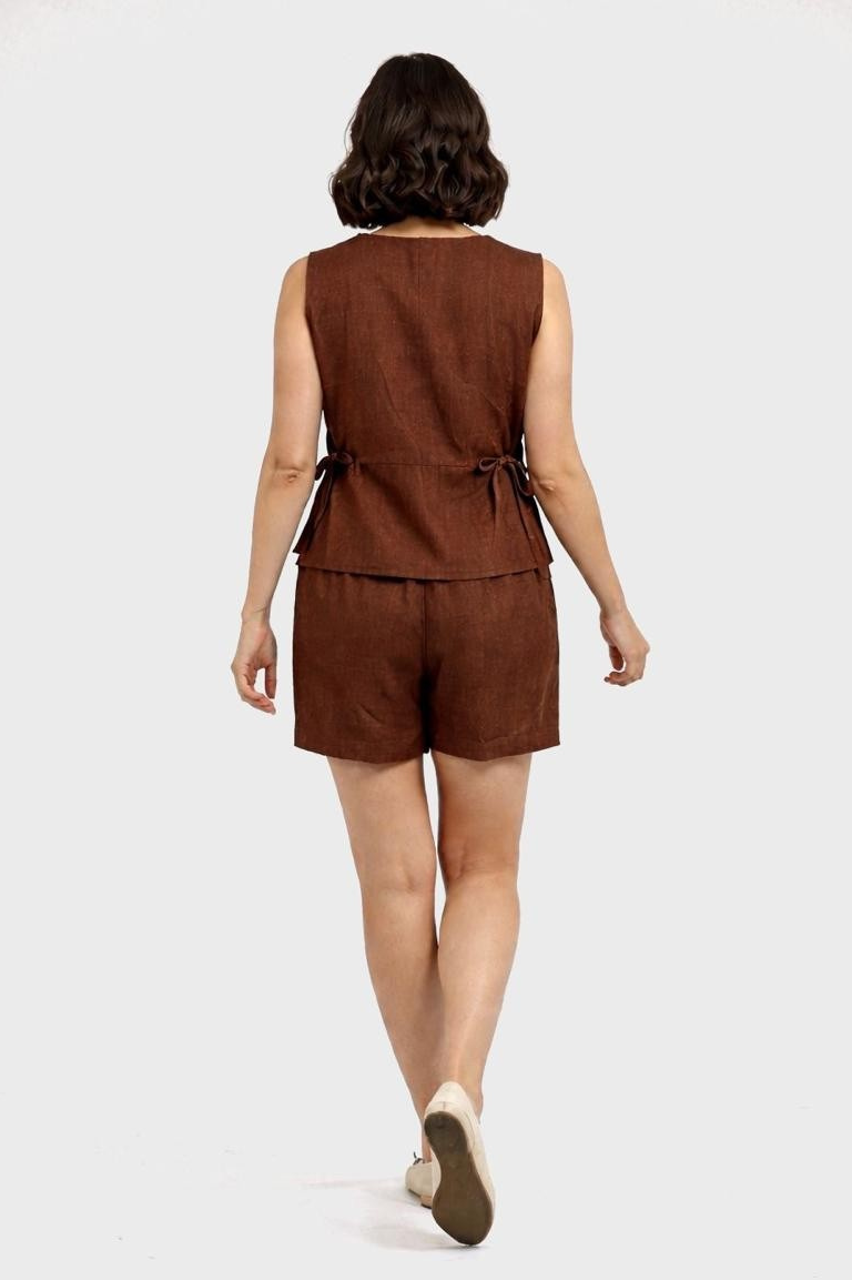 Woman wearing a brown sleeveless top and shorts set on a white background