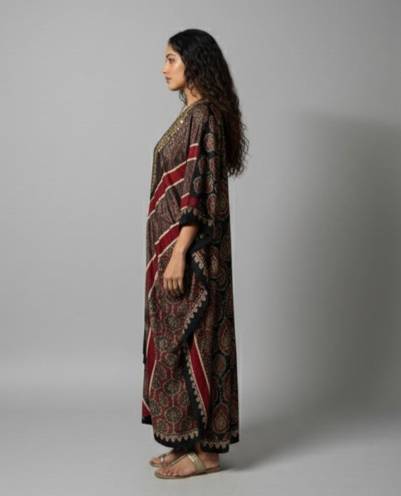 Woman wearing a long, patterned dress against a plain background