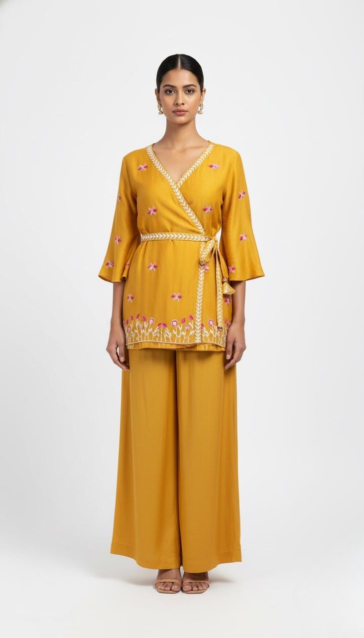 Woman wearing a mustard yellow outfit with floral embroidery on a white background