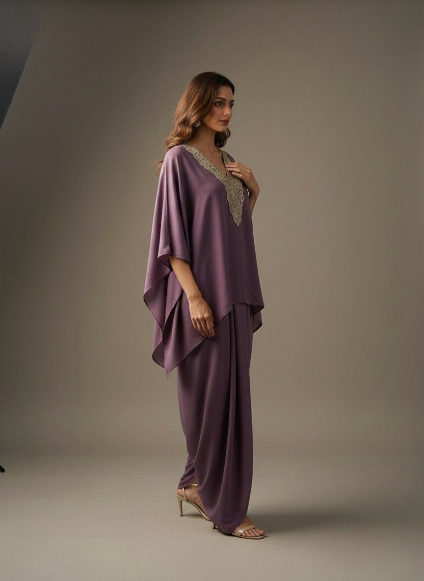 Woman wearing a purple outfit with a textured top against a gray background