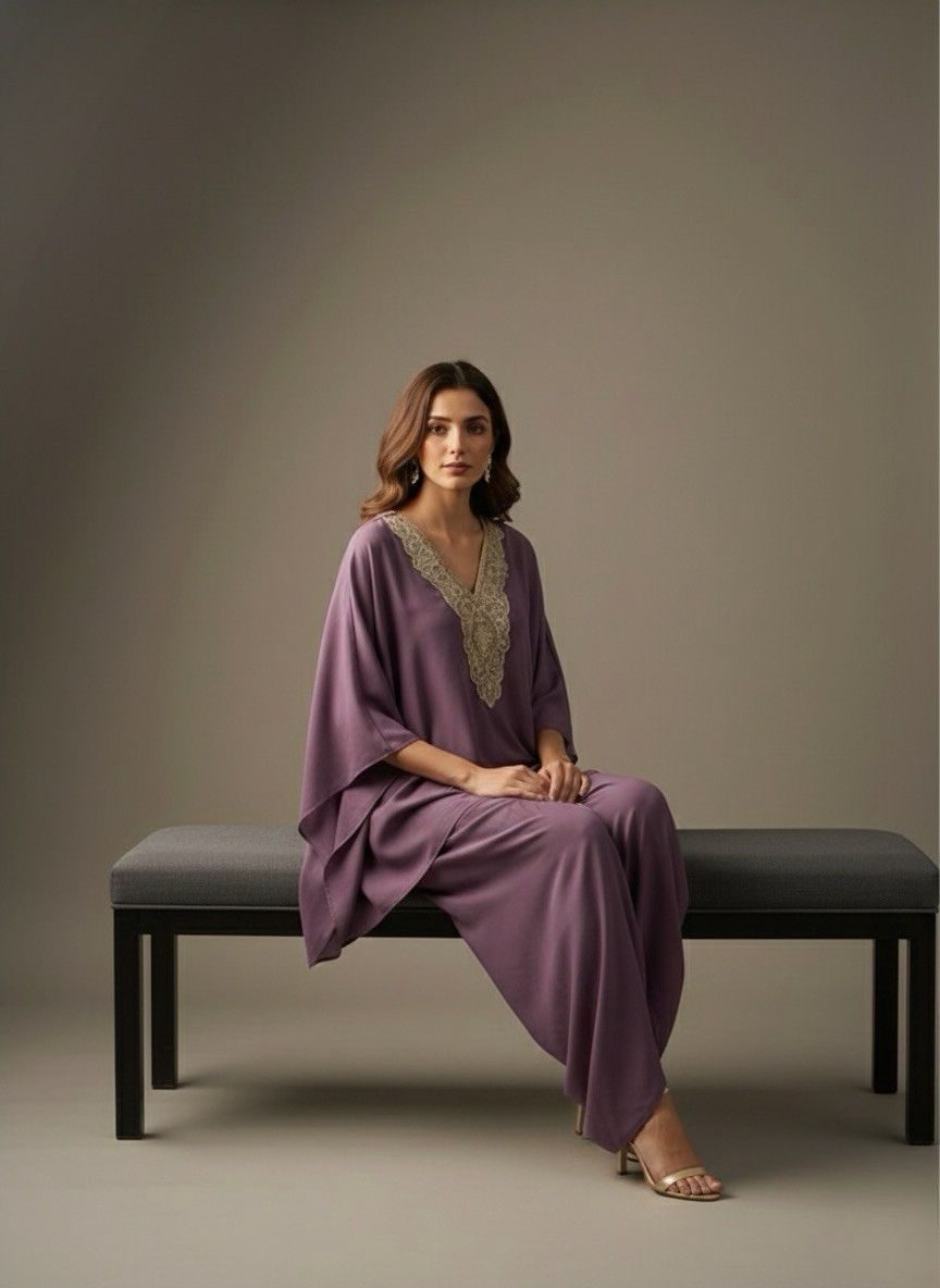Woman in a purple outfit sitting on a bench against a plain background