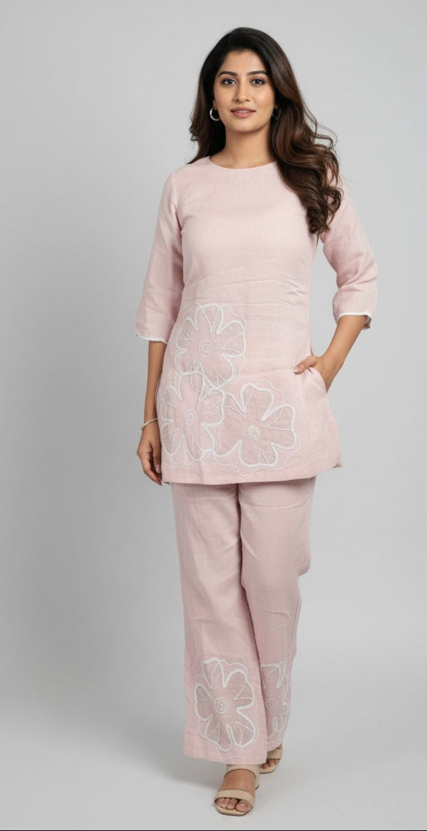 Woman wearing a light pink outfit with floral patterns on a gray background