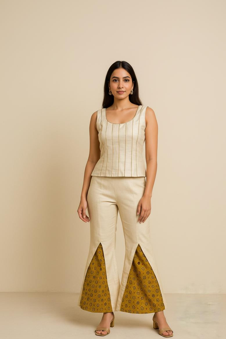 Woman wearing a beige top and patterned pants on a beige background