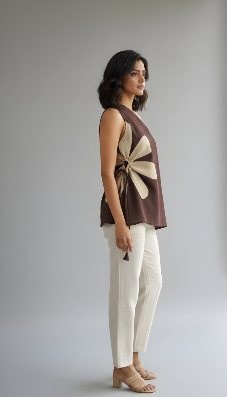 Modern asymmetric brown top with sculptural appliqué detail styled with neutral pants for an elegant contemporary look