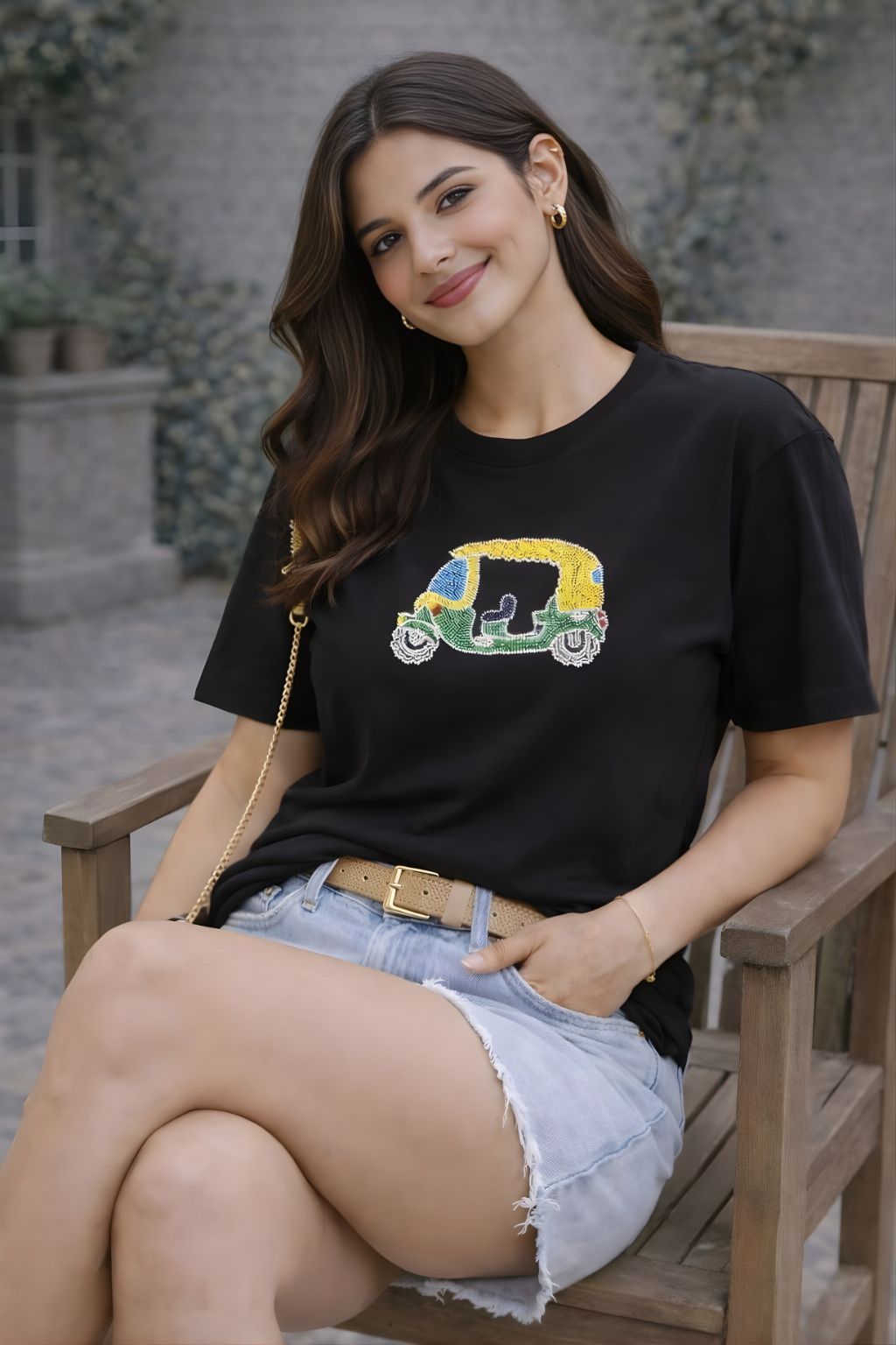 Woman wearing black graphic tee with auto rickshaw embellishment styled with denim shorts.