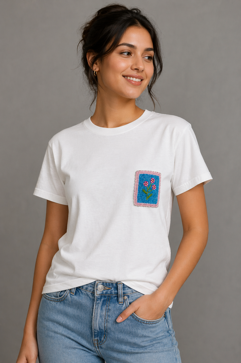 Close-up of hand-beaded floral design on white t-shirt