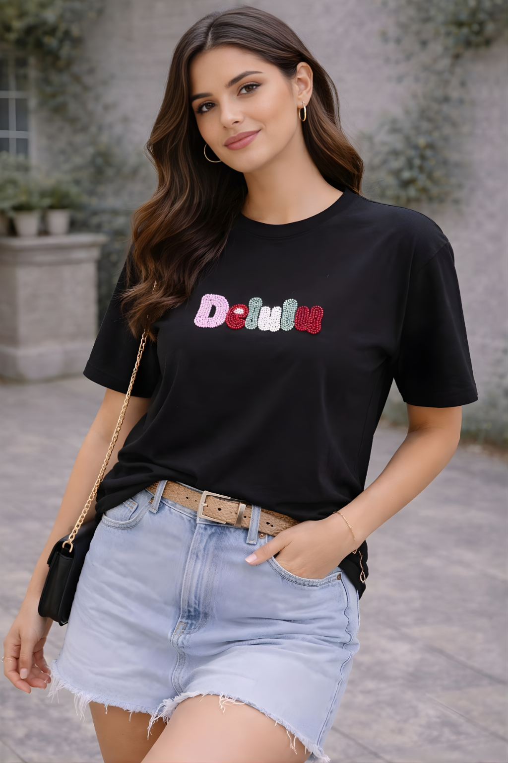 Black women’s T-shirt with colorful Delulu embellished lettering graphic.