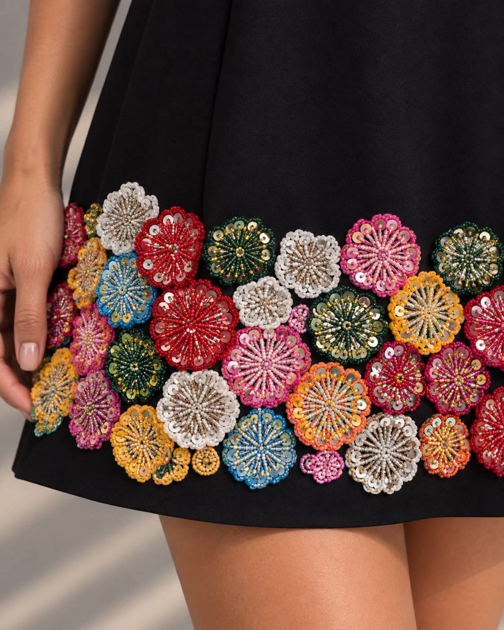 Black mini dress with colorful floral hem embellishment