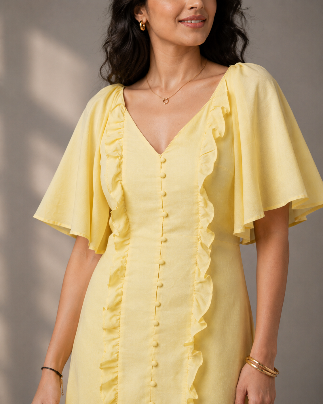 Close-up of the butter yellow maxi dress highlighting ruffle detailing, front buttons and flutter sleeves.