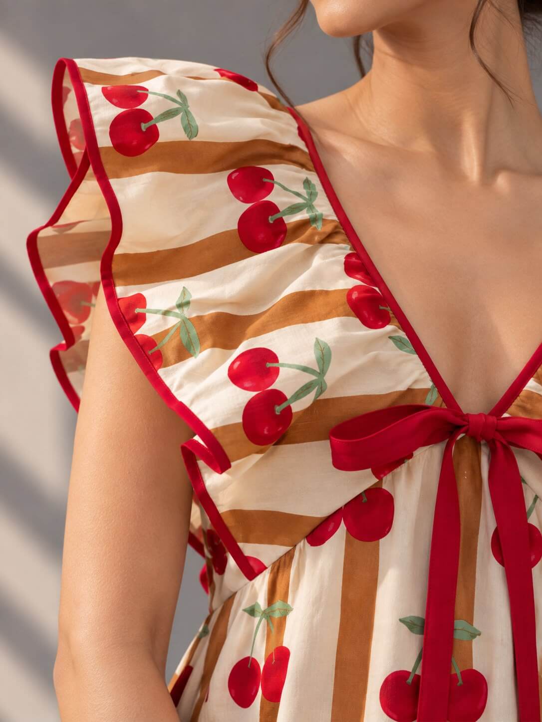 Close-up of layered ruffle sleeves and cherry print detail on the Cherry Stripe Mini Dress
