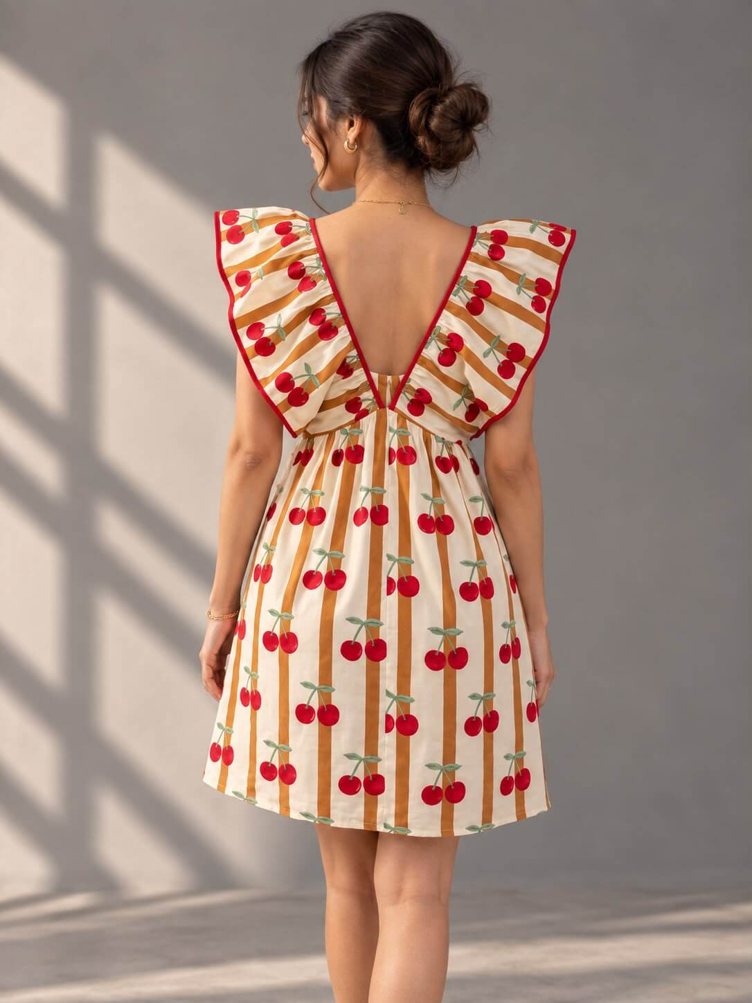 Back view of Cherry Stripe Ruffle Mini Dress featuring deep V-back and cherry print