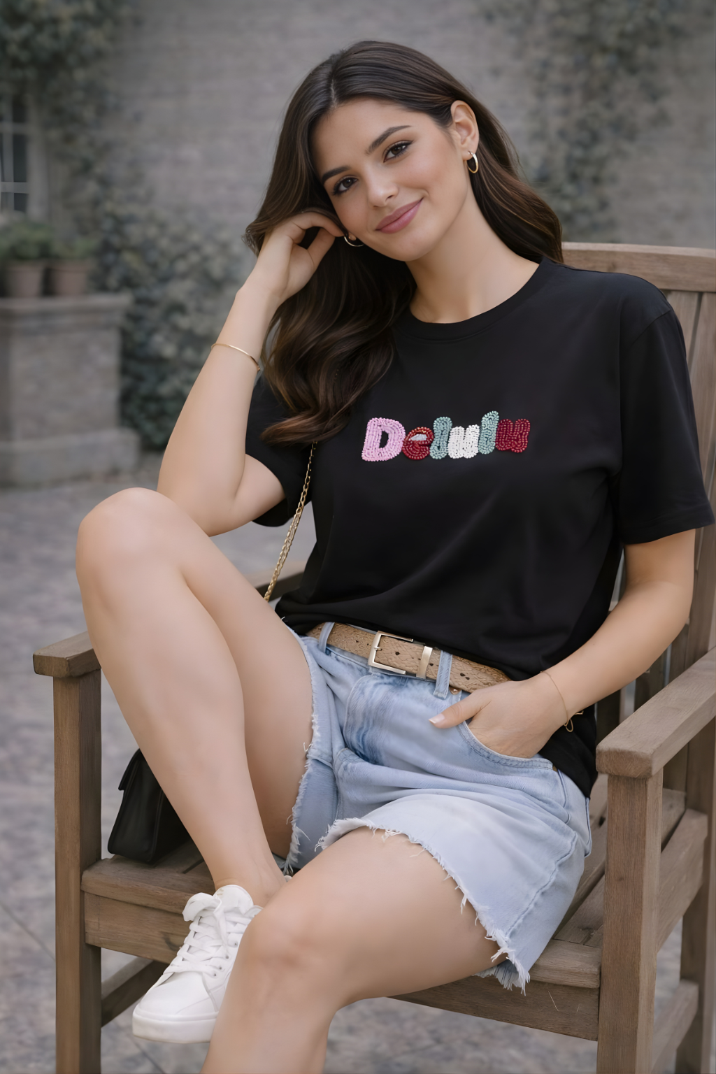 Woman wearing black Delulu statement T-shirt styled with denim shorts