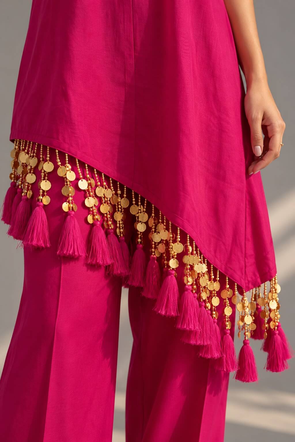 Fuchsia pink top featuring a deep V neckline and golden decorative work