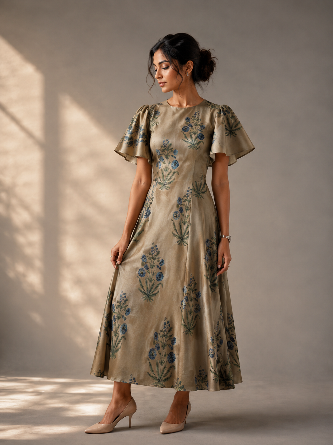 Golden floral modal silk midi dress in elegant walking pose with soft sunlight