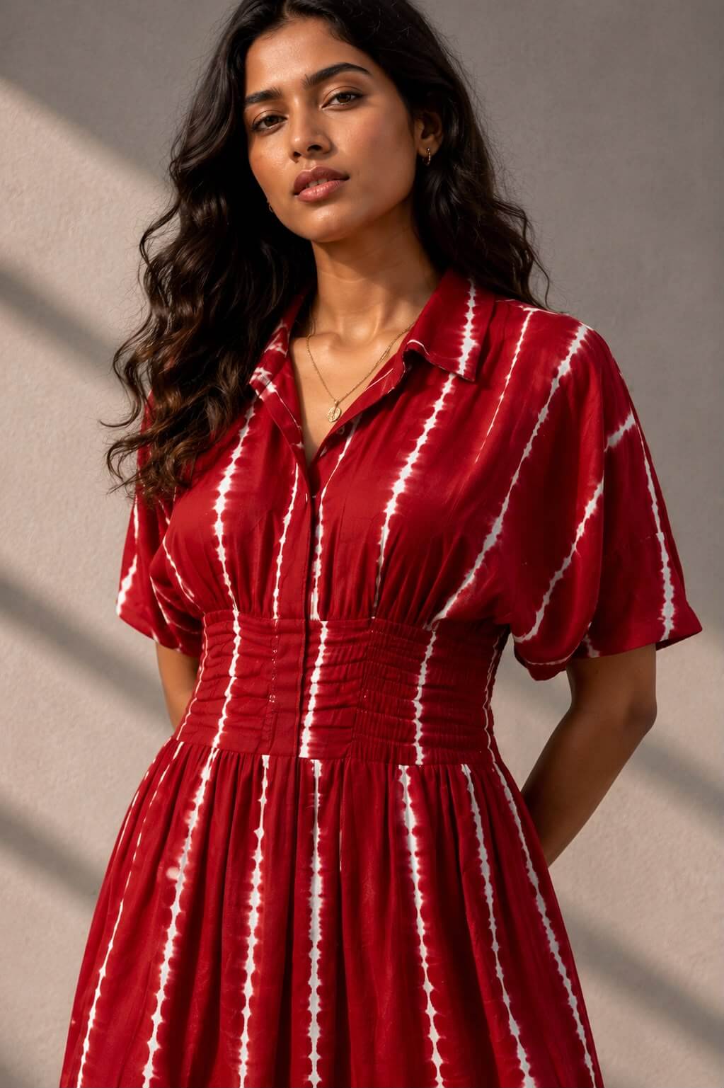 Elegant red Shibori tie-dye cotton midi dress featuring a flattering smocked waist and flared silhouette.
