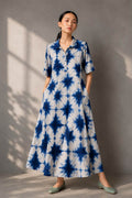 Woman wearing an indigo and white shibori print cotton maxi dress with pockets.