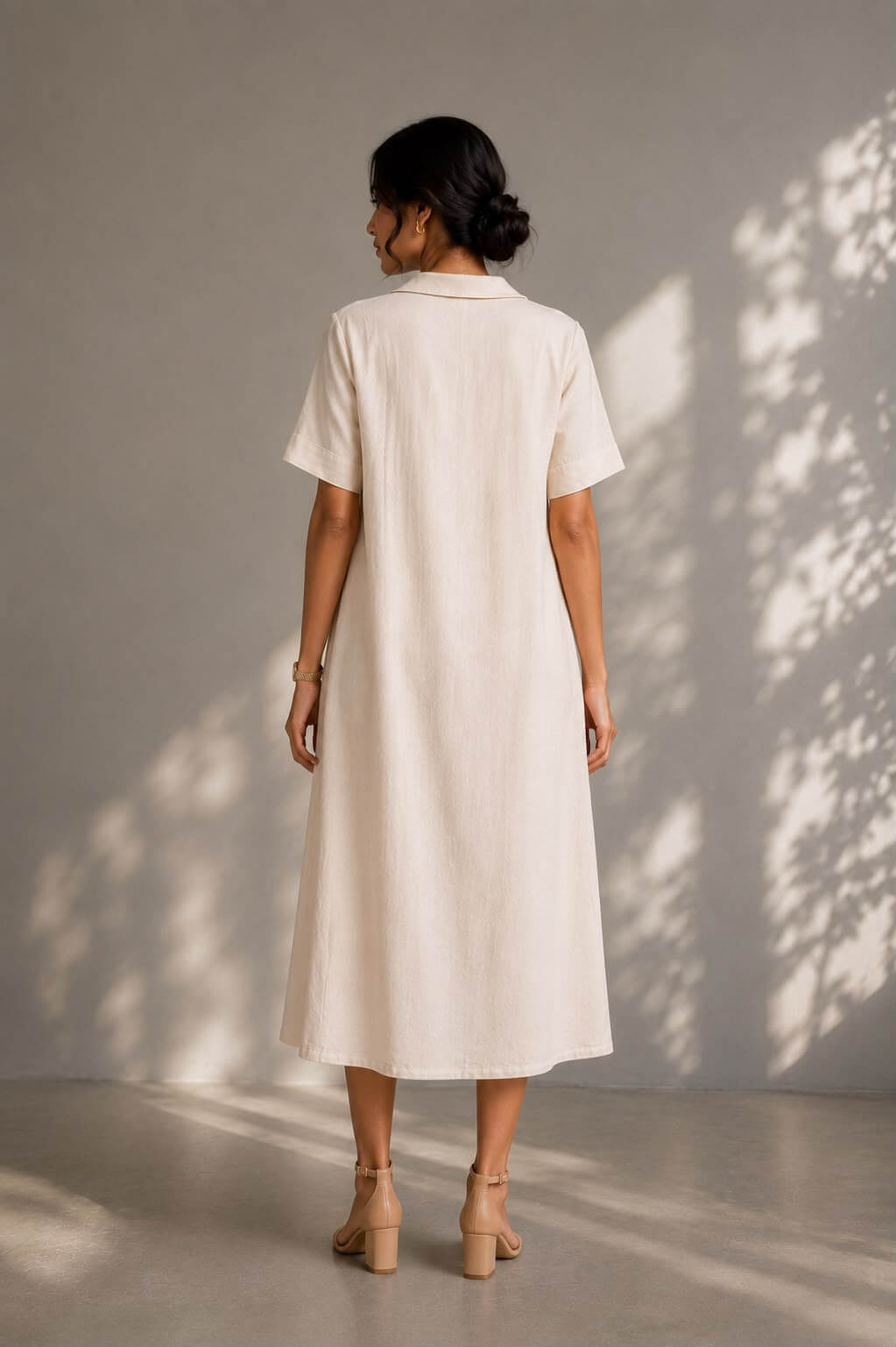 Elegant white cotton A-line dress with delicate leaf embroidery and pockets.