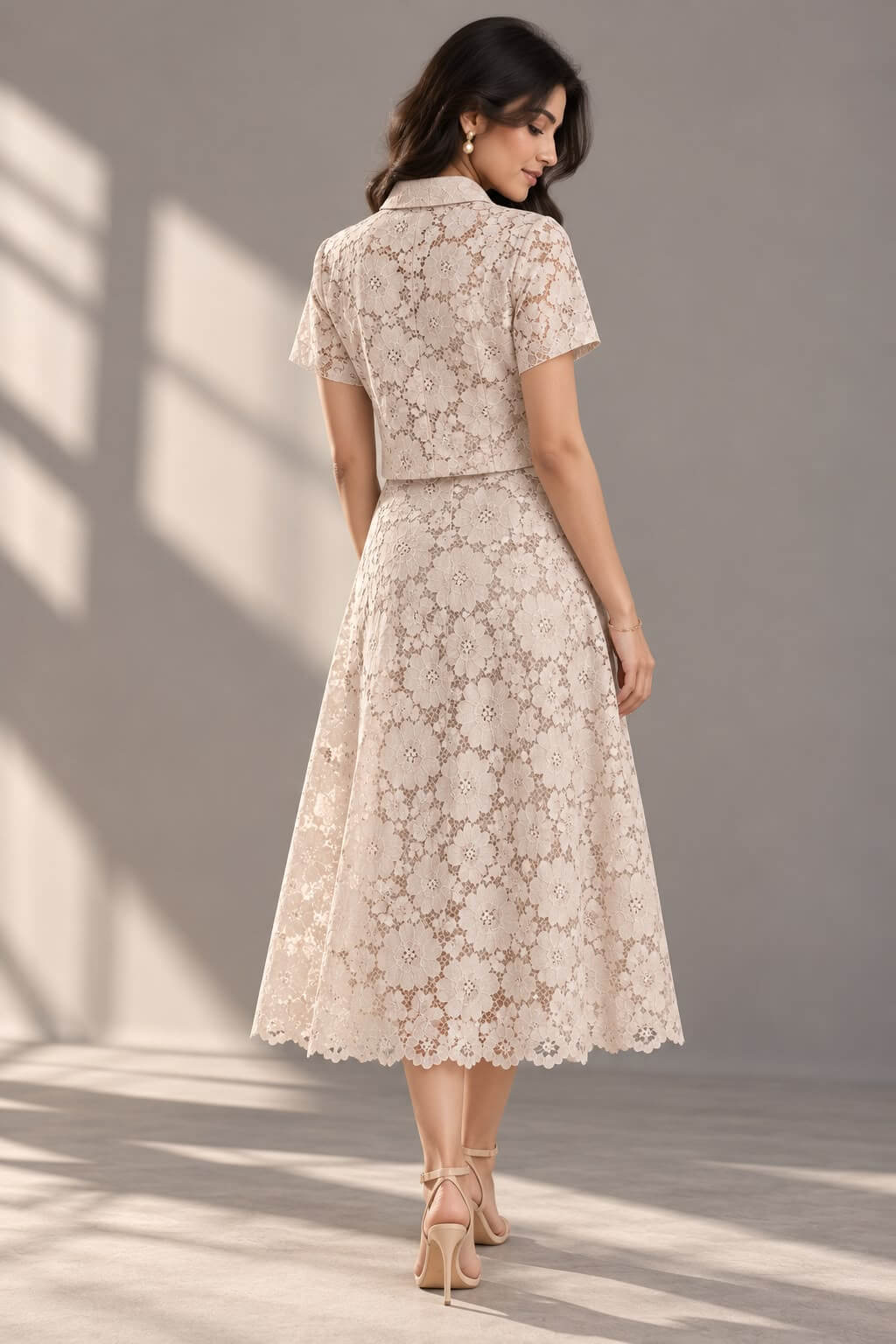 Back view of the ivory floral lace co-ord set featuring a short-sleeve shirt and scalloped A-line midi skirt.
