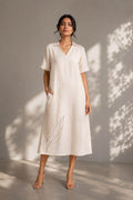 Model wearing an ivory leaf embroidered cotton midi dress by Gehru Label.