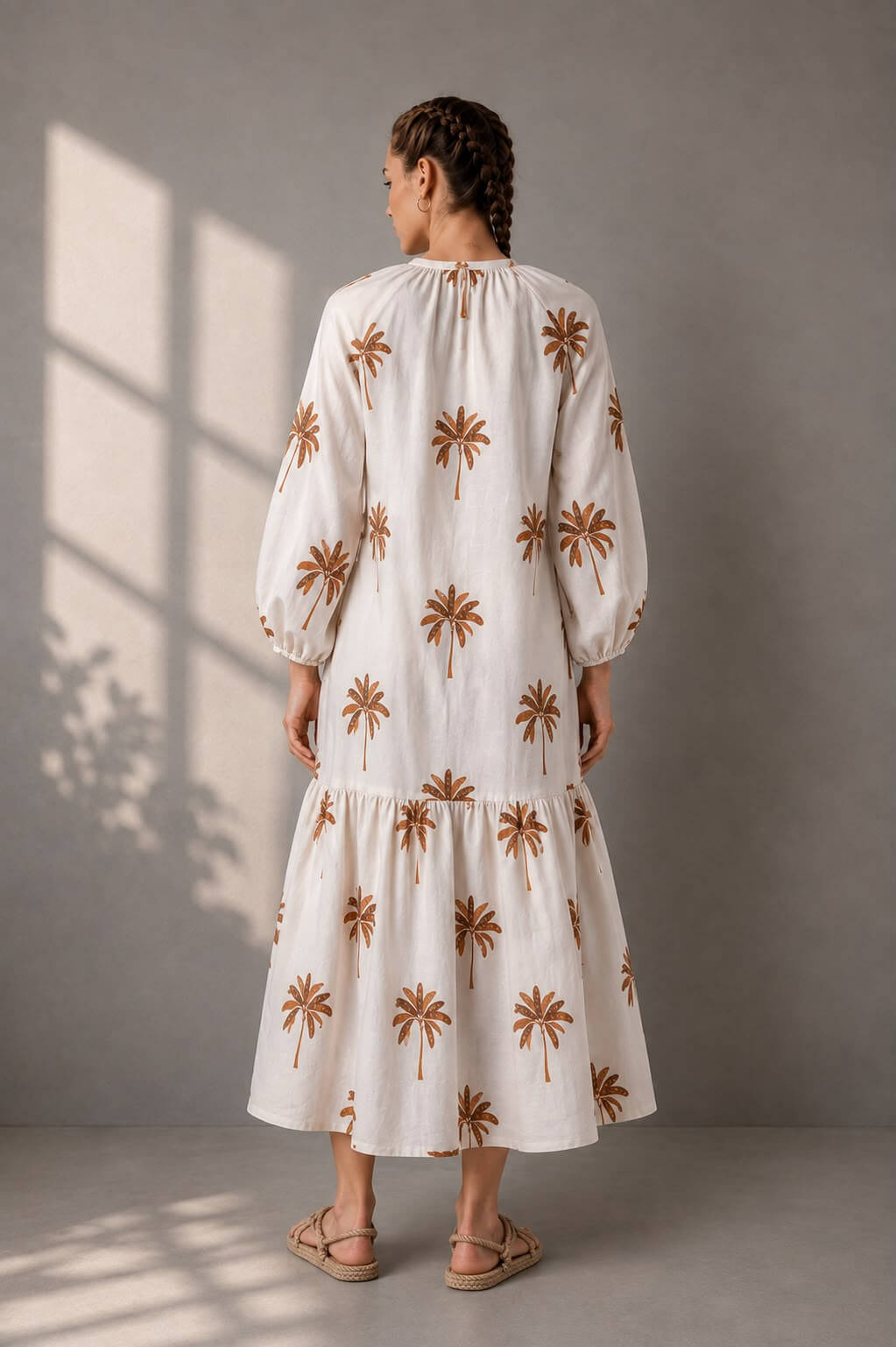Resort-style cotton dress featuring palm tree motifs and tiered hem.