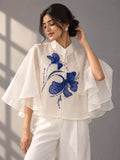 Front view of ivory cotton top with blue tubelight embellishment and layered ruffle sleeves