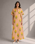 Woman wearing a cotton lemon print striped maxi dress with a V-neck collar and relaxed sleeves.