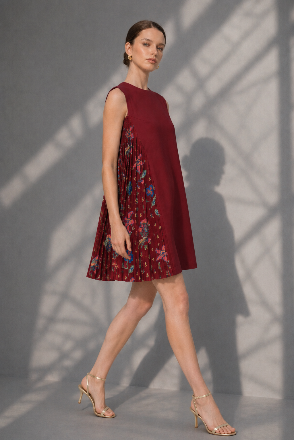 Side walking pose of maroon pleated floral panel dress for women