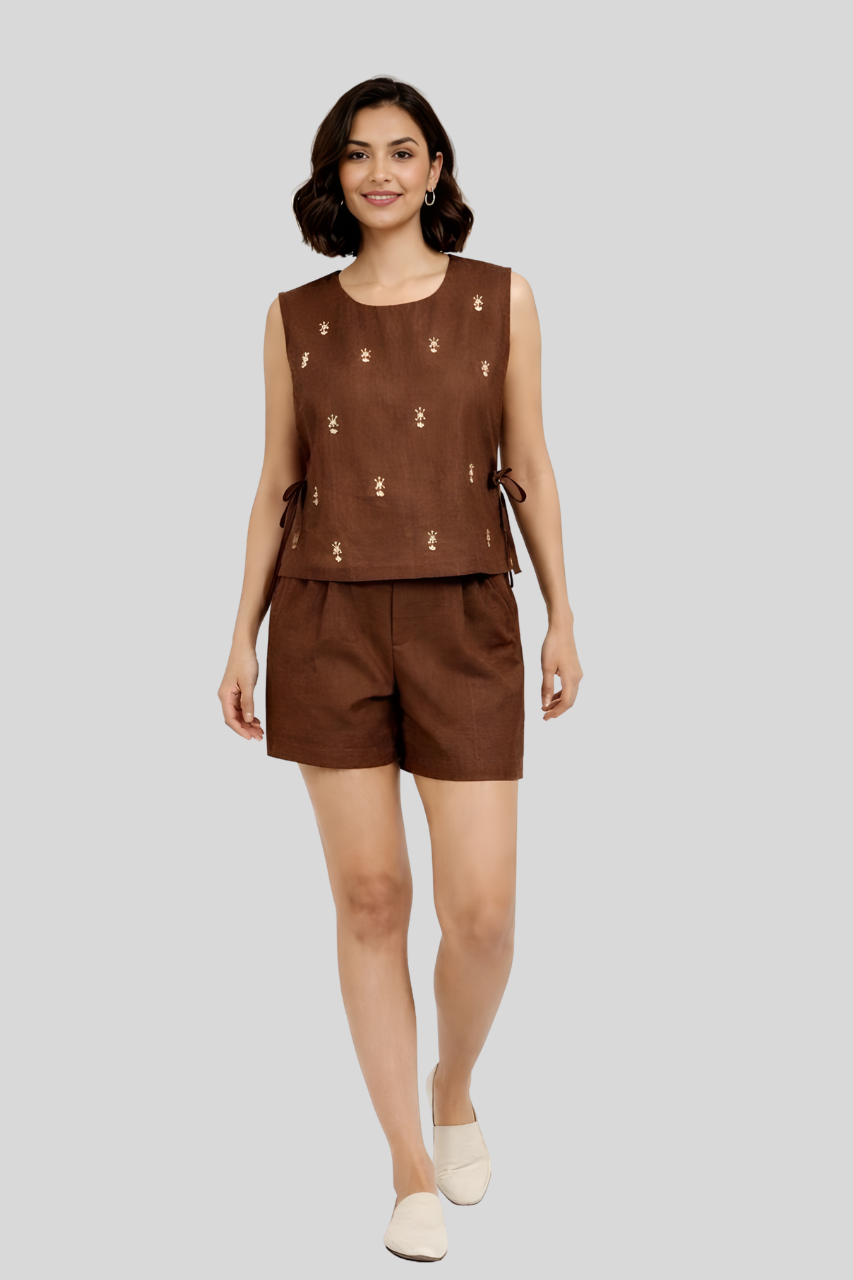 Woman wearing a brown sleeveless top and shorts on a light gray background