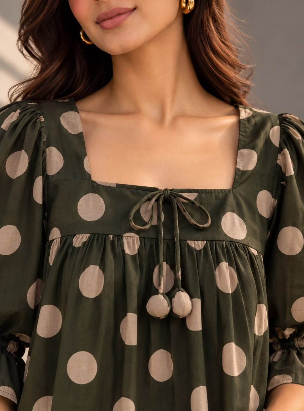 Close-up of olive green cotton top with polka dot print