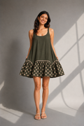  Woman wearing olive green mini dress with polka dot frill hem front pose