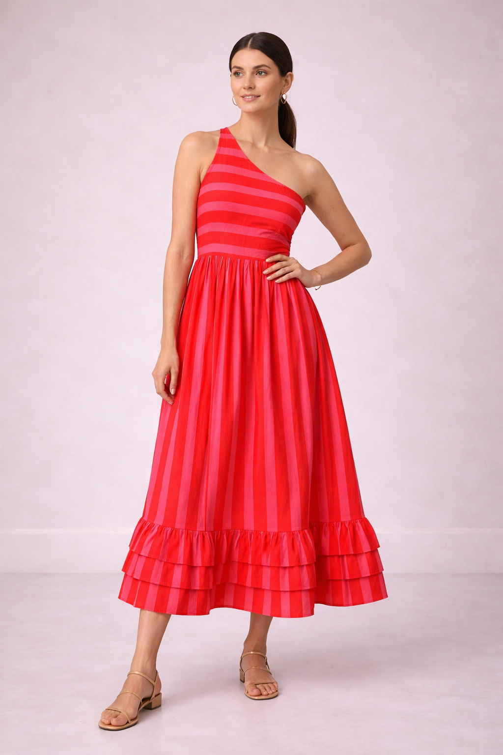 Woman wearing a pink one-shoulder dress on a light background