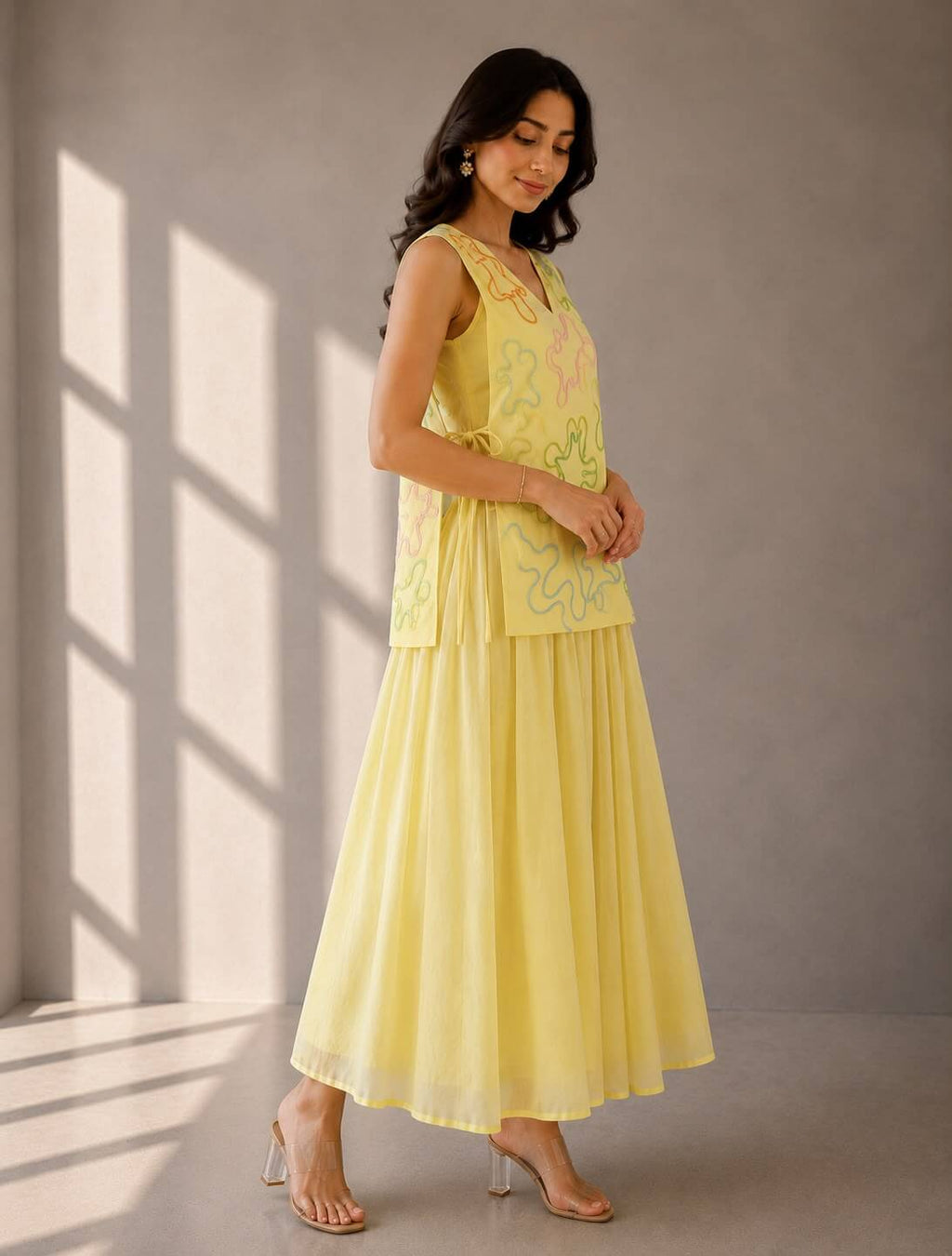 Contemporary butter yellow layered dress set with an embellished sleeveless vest and flowing umbrella silhouette.