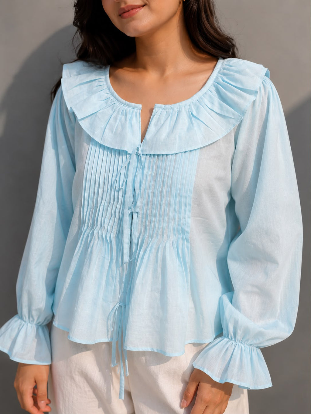 Breathable cotton top with front tie-up and frilled cuffs.