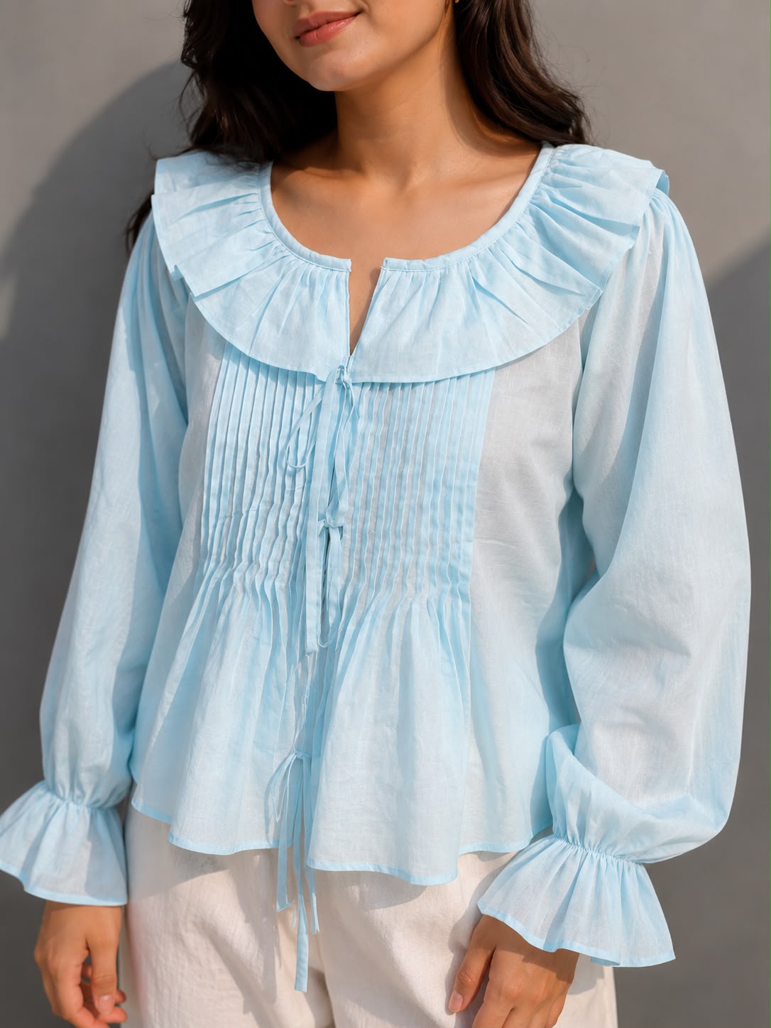 Breathable cotton top with front tie-up and frilled cuffs.