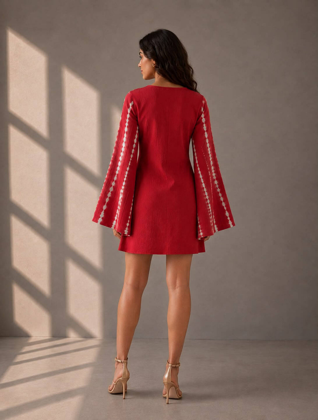 Red cotton A-line dress featuring statement sleeves and tie-up neckline.