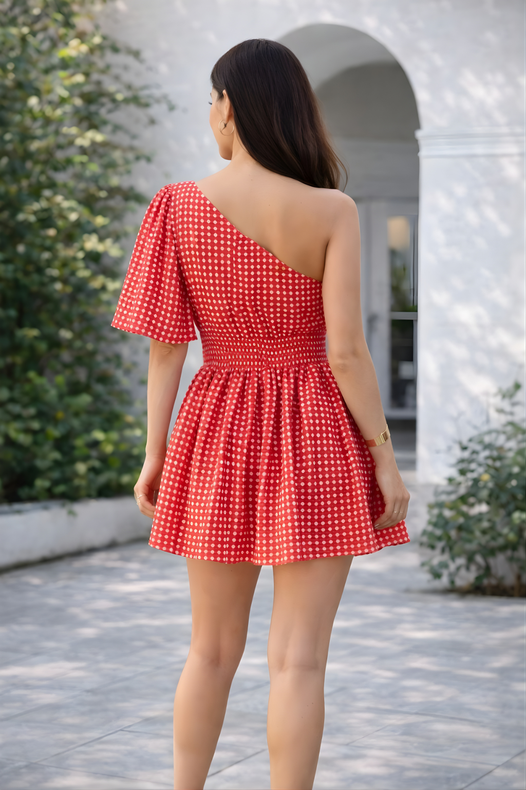 Woman wearing red one shoulder mini dress with puff sleeve