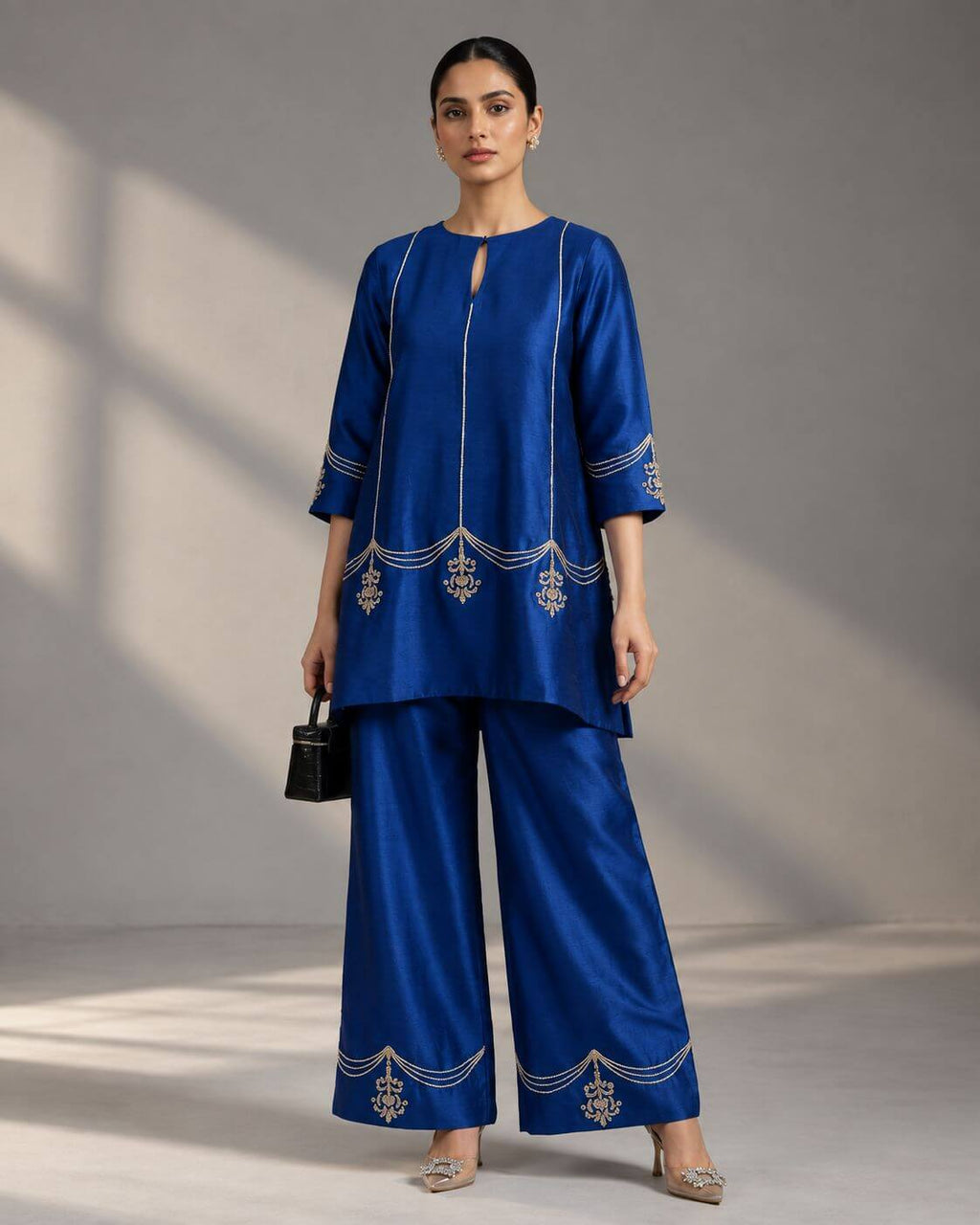 Woman wearing a royal blue crape silk co-ord set with Zardosi embroidery