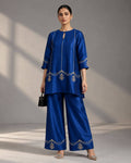 Woman wearing a royal blue crape silk co-ord set with Zardosi embroidery