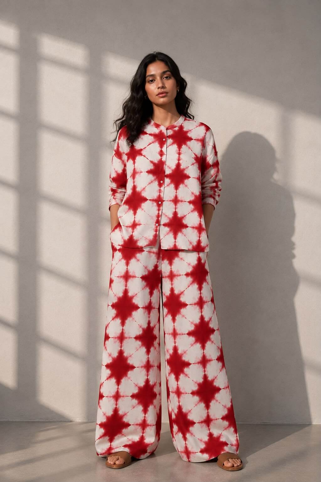 Woman wearing a handcrafted red and ivory tie-dye cotton co-ord set with a button-down shirt and wide-leg trousers.