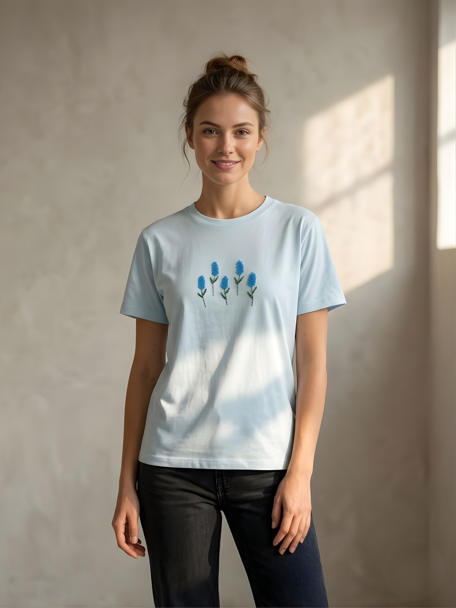 Sky blue cotton t-shirt for women with minimal floral embroidery paired with black jeans casual outfit