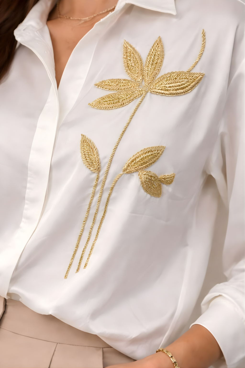 Close-up of intricate gold zardosi embroidery on white shirt