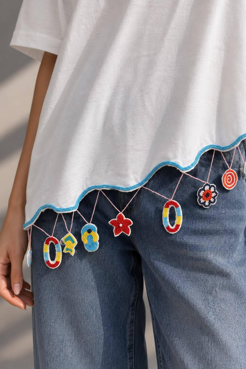 White women's T-shirt with blue piping and embellished hem